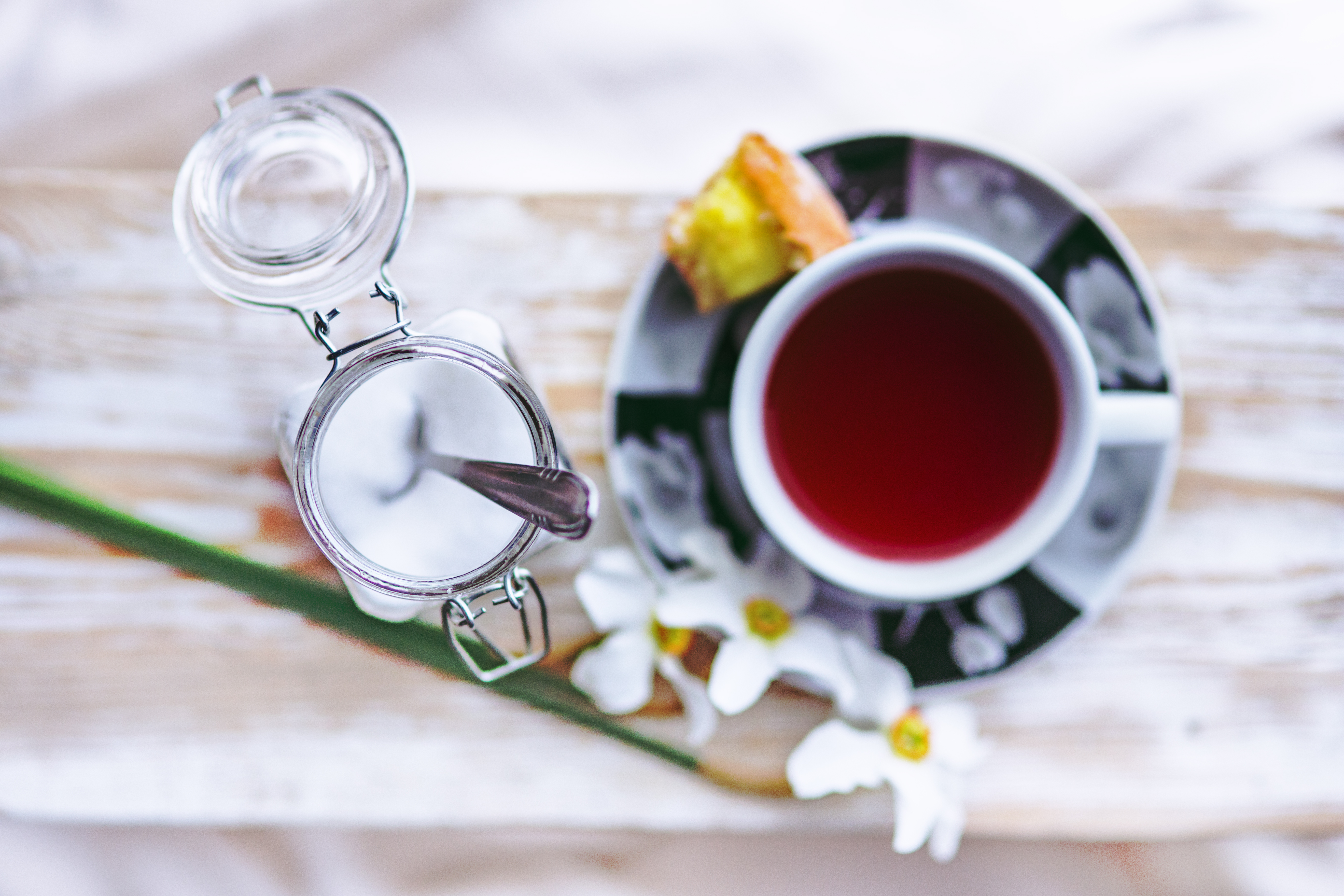 cup of tea with sugar and a small piece of cake